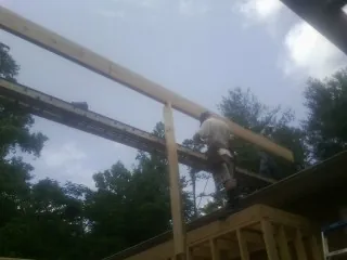 Carpenter setting a ridge beam over a new addition frame — Ice Dam Removal by Roofing Brothers in Bethpage