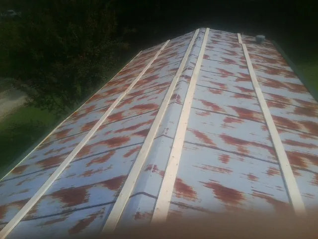 Rusted metal roof panels with new wood purlins before replacement — Storm Damage Roof Repair in Bethpage by Roofing Brothers