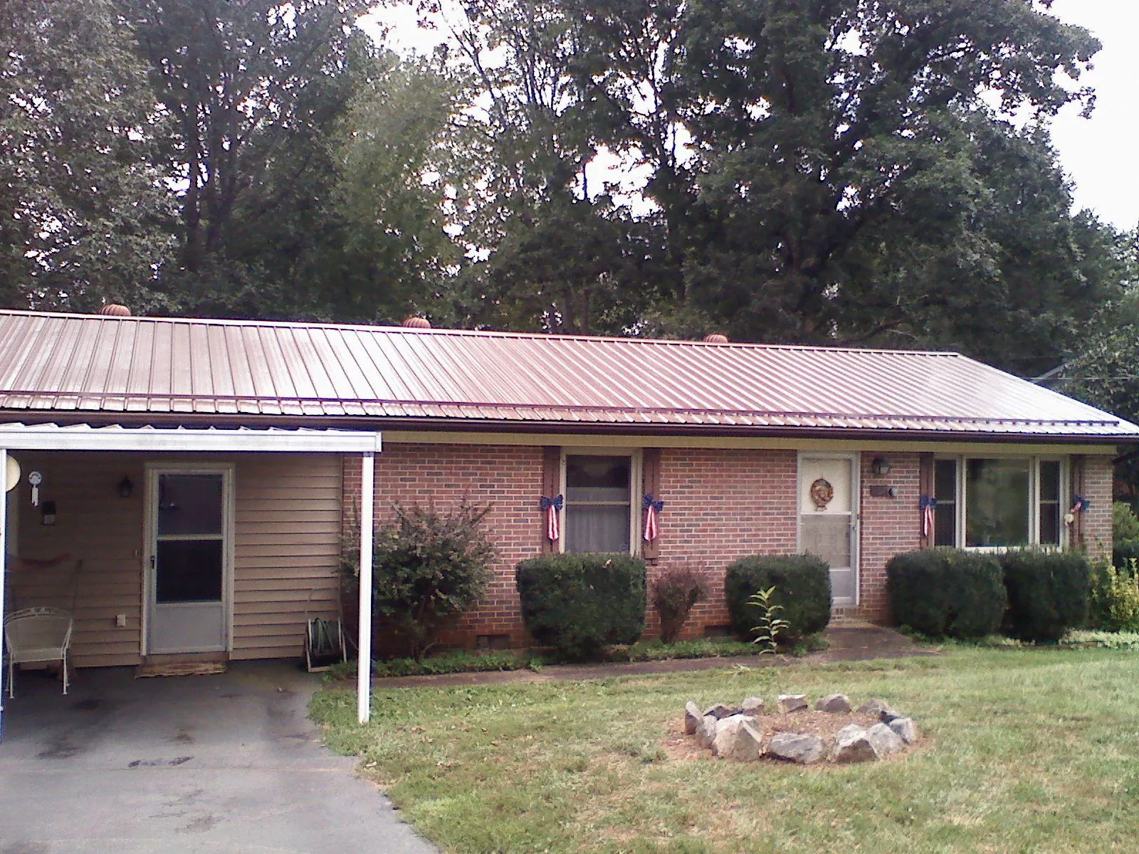 Bronze metal roof and carport on a brick ranch home — Roof Repair work by our crew in Bethpage