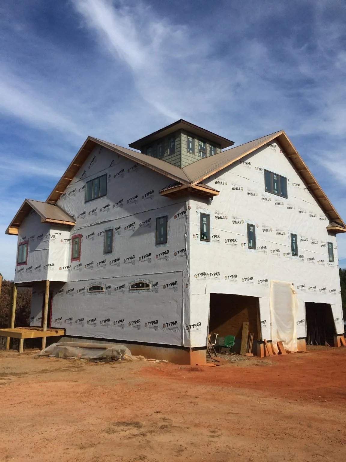 New two story house under construction with a cupola and gabled roofs in Bethpage